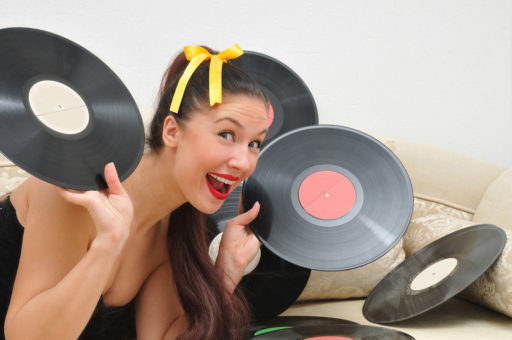 Caucasian woman smiling and holding vinyl records
